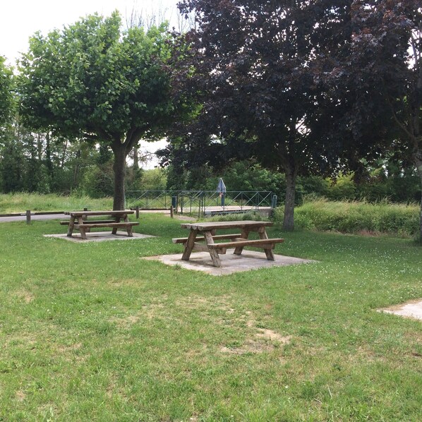 Un parque con mesas de picnic y un sendero para caminar.