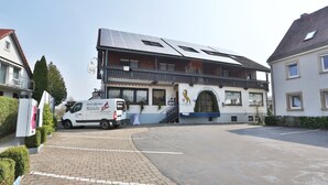 Un hôtel à deux étages, doté d’un balcon et de panneaux solaires sur le toit.