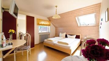 Una habitación pequeña y acogedora con cama, escritorio, silla y televisión.
