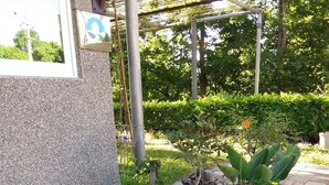 Ein gepflasterter Weg mit Blumentöpfen und einer Metallkonstruktion.