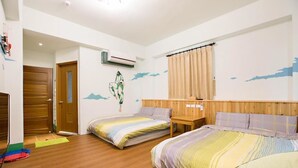 Ein Schlafzimmer mit zwei Betten, Holzboden, einem Holz-Kopfteil, einem kleinen Tisch und einem Fenster mit Vorhängen.