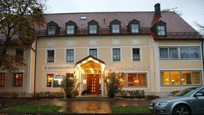 Een hotel in traditionele Europese bouwstijl, met een symmetrische gevel, meerdere ramen en een centrale ingang met een luifel.