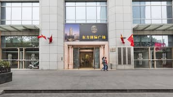 A building entrance with a sign reading "东方国际广场" and two red flags.
