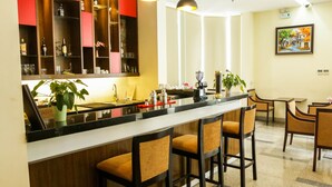 Une cuisine moderne dotée d’un bar, de tabourets de bar et d’un coin repas avec des chaises.