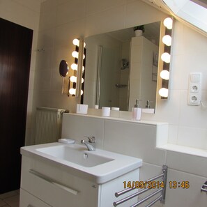 A bathroom with a large mirror, vanity, and a shower. - Ferienwohnung Em Gardestüffje (Mechernich)