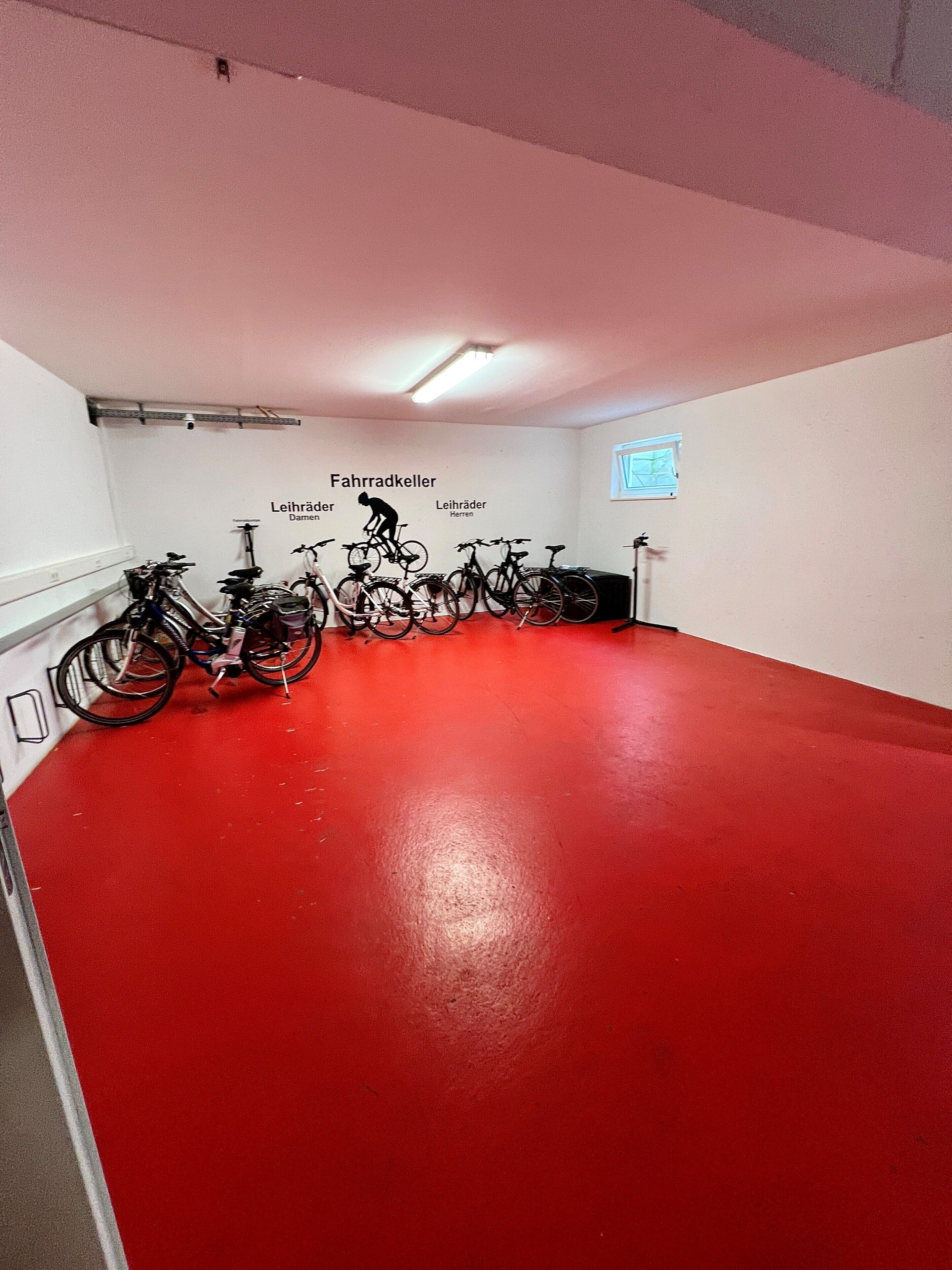 A red-tiled room with bicycles and a projector screen.