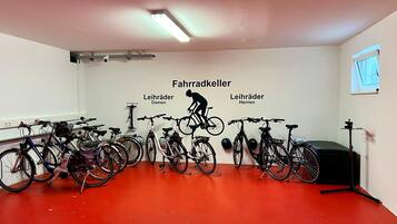 A room with bicycles, a ceiling-mounted projector, and a red floor.