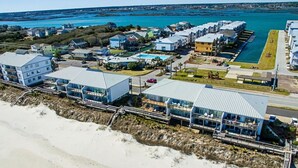 A coastal hotel with multiple buildings, a beach view, and a swimming pool. - Queen's Grant 211-C | Oceanfront + Sound Views! (Topsail Beach)
