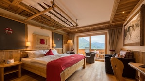Ein Zimmer mit Holzboden, einem Bett, einem Schreibtisch und einem Stuhl.
