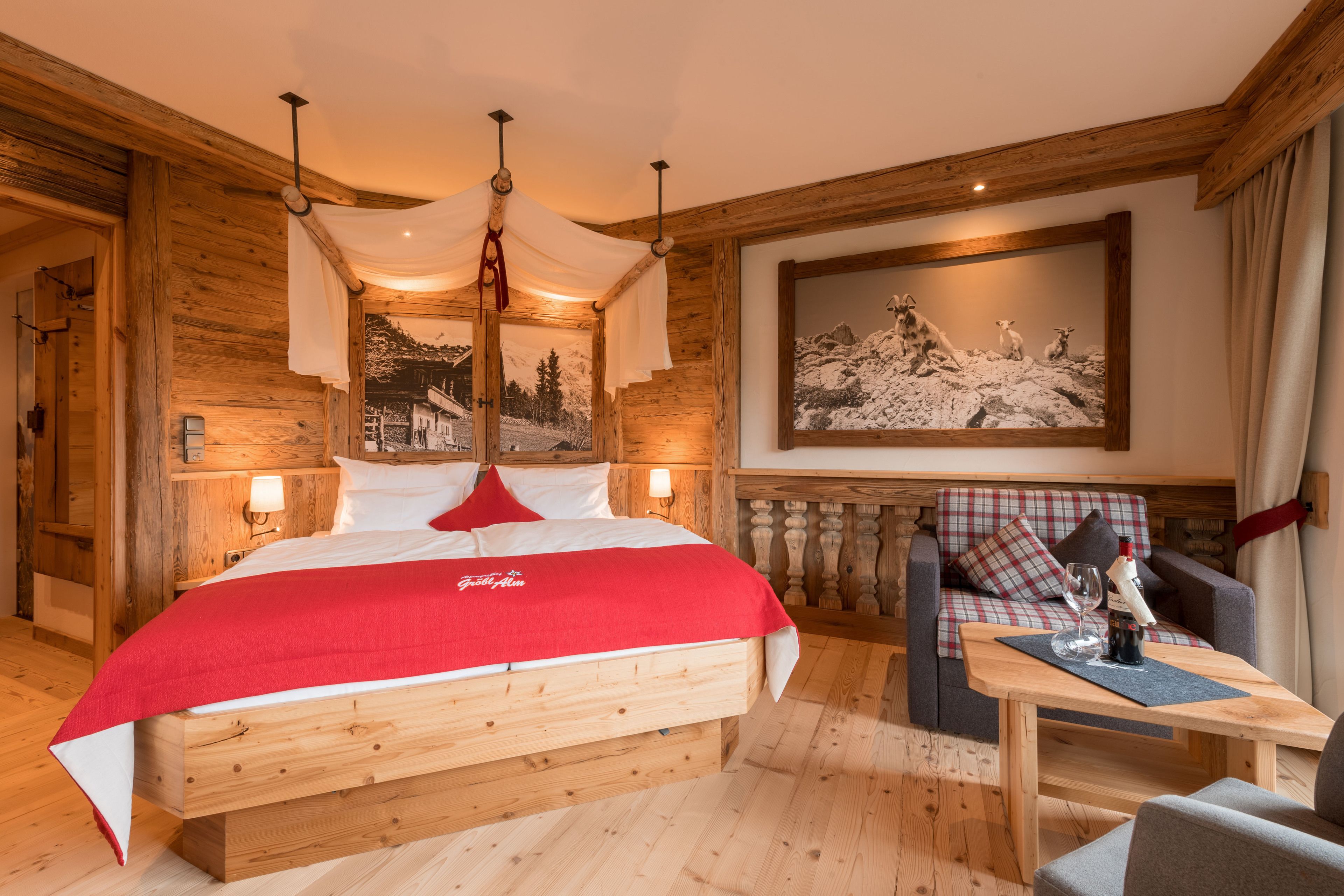 Una habitación de madera con una cama, un sofá y una mesa.