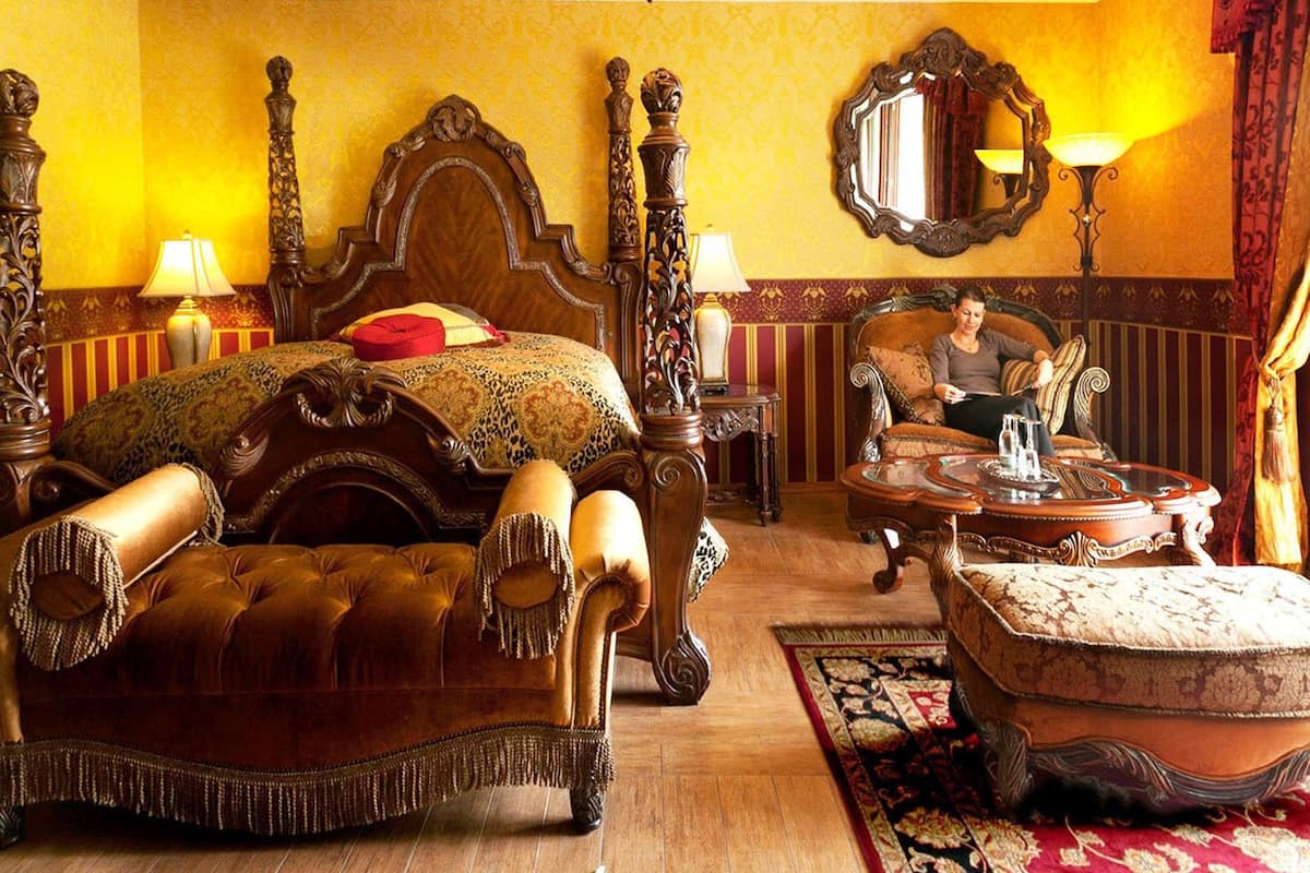 Ein luxuriöses Schlafzimmer mit einem großzügigen Himmelbett, aufwendigen Möbeln und klassischer Einrichtung.