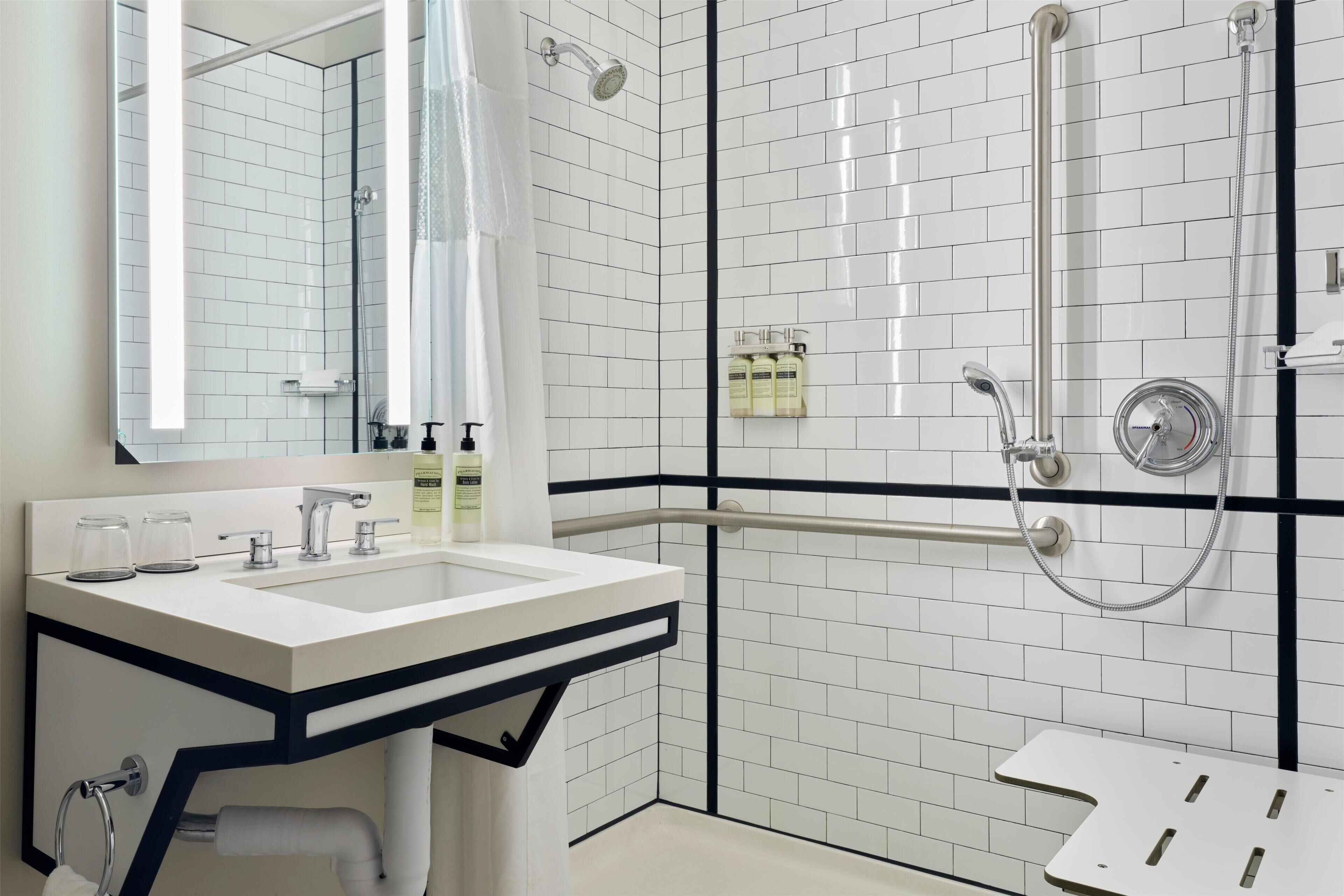 A modern bathroom with a white sink, mirror, and shower.