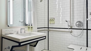 A modern bathroom with a white sink, mirror, and shower.