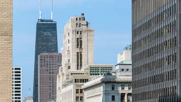 A cityscape with various buildings, including a tall skyscraper and a historic building with a clock tower.