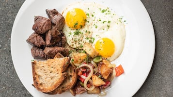 A plate of food with eggs, meat, and vegetables.