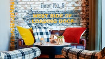 Een gezellige zithoek met een bakstenen muur en een bord waarop staat: 'WEST SIDE OF LOADING DOCK'.