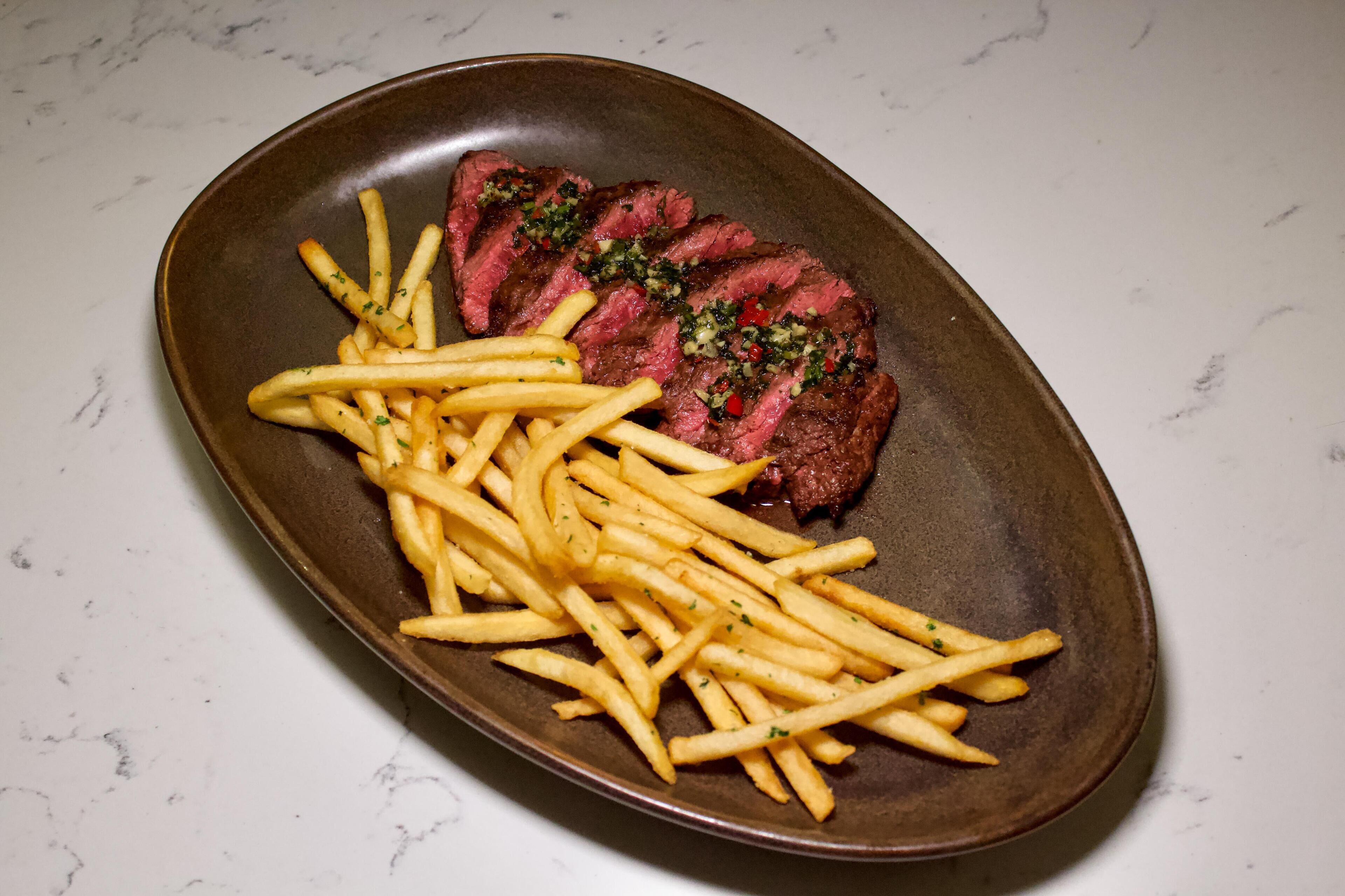 Un plato con bistec y papas fritas.
