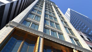 A high-rise building with a modern architectural design, featuring a prominent glass facade and a series of vertical lines. - Arlo Chicago (Chicago)