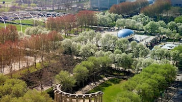Vista aérea de un parque con una gran estructura en forma de cúpula azul, senderos y un pabellón con columnas de estilo clásico.