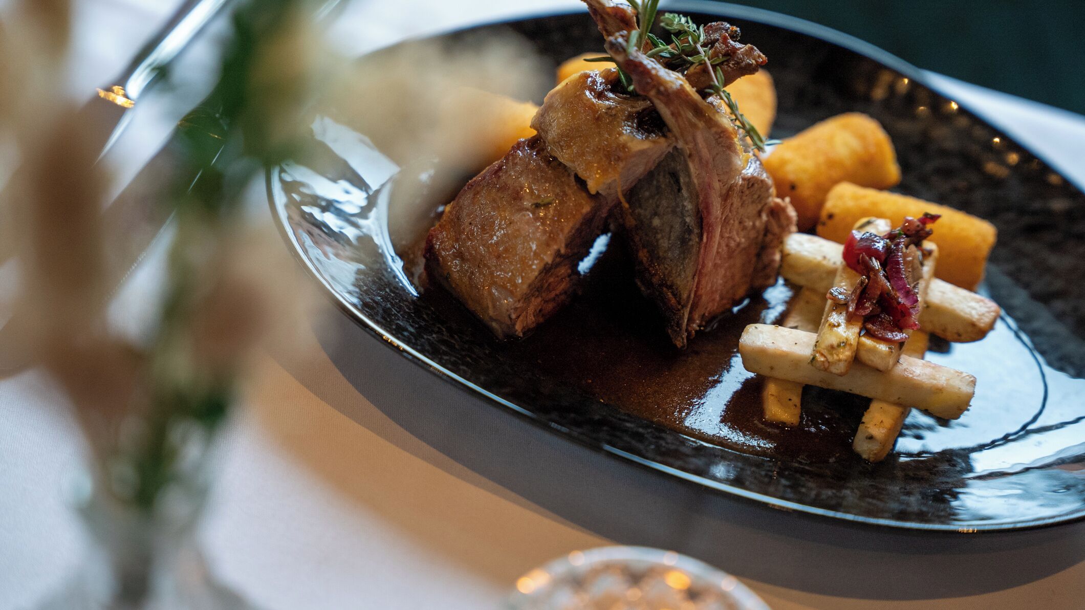 A plate of food with meat, potatoes, and a sauce.