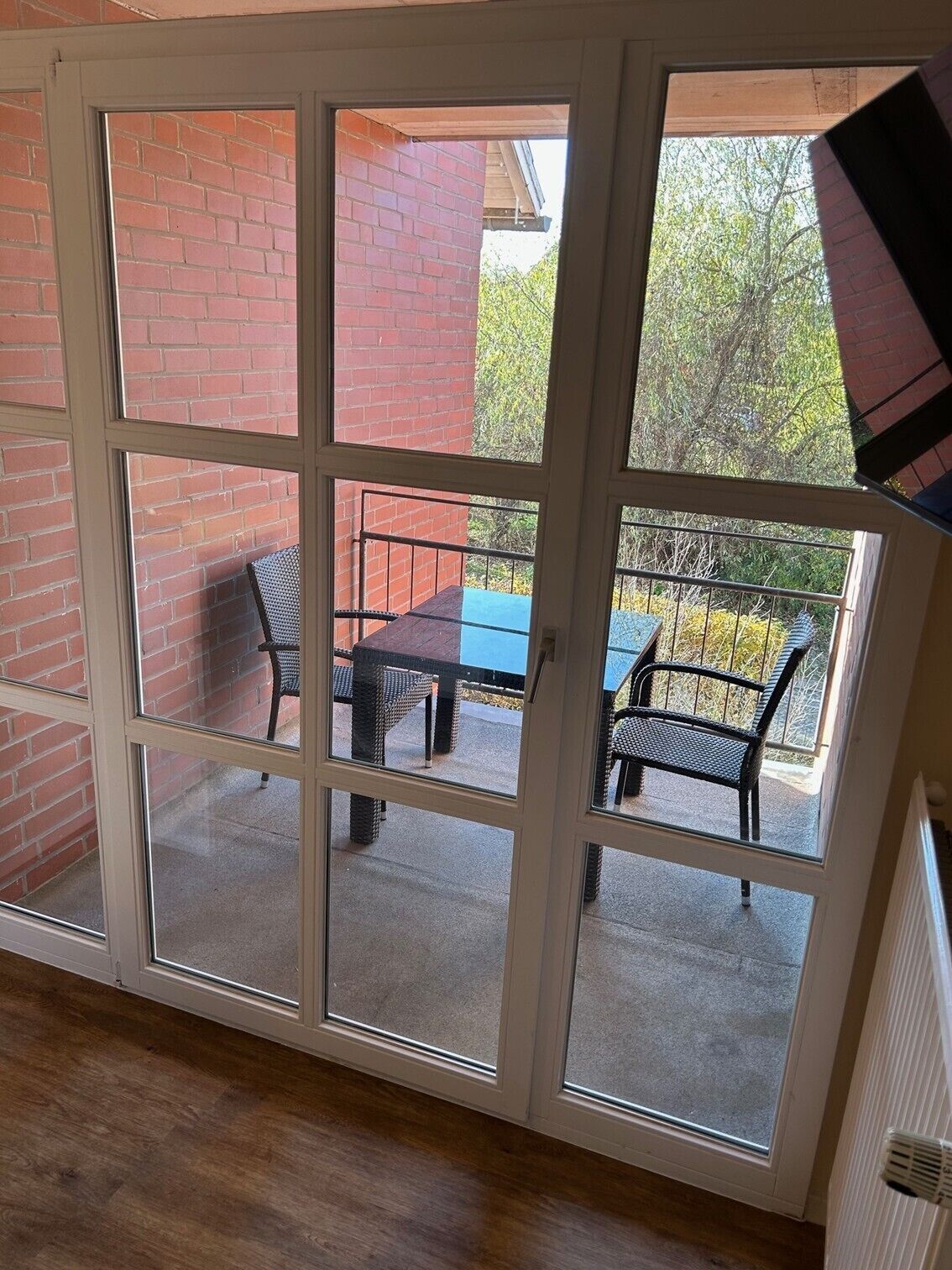 A room with a sliding glass door leading to an outdoor patio with a table and chairs.