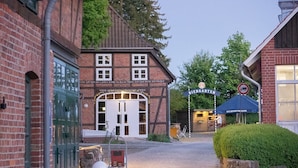 Une rue pavée menant à un bâtiment traditionnel sur lequel on peut lire l’inscription « Biergarten ».