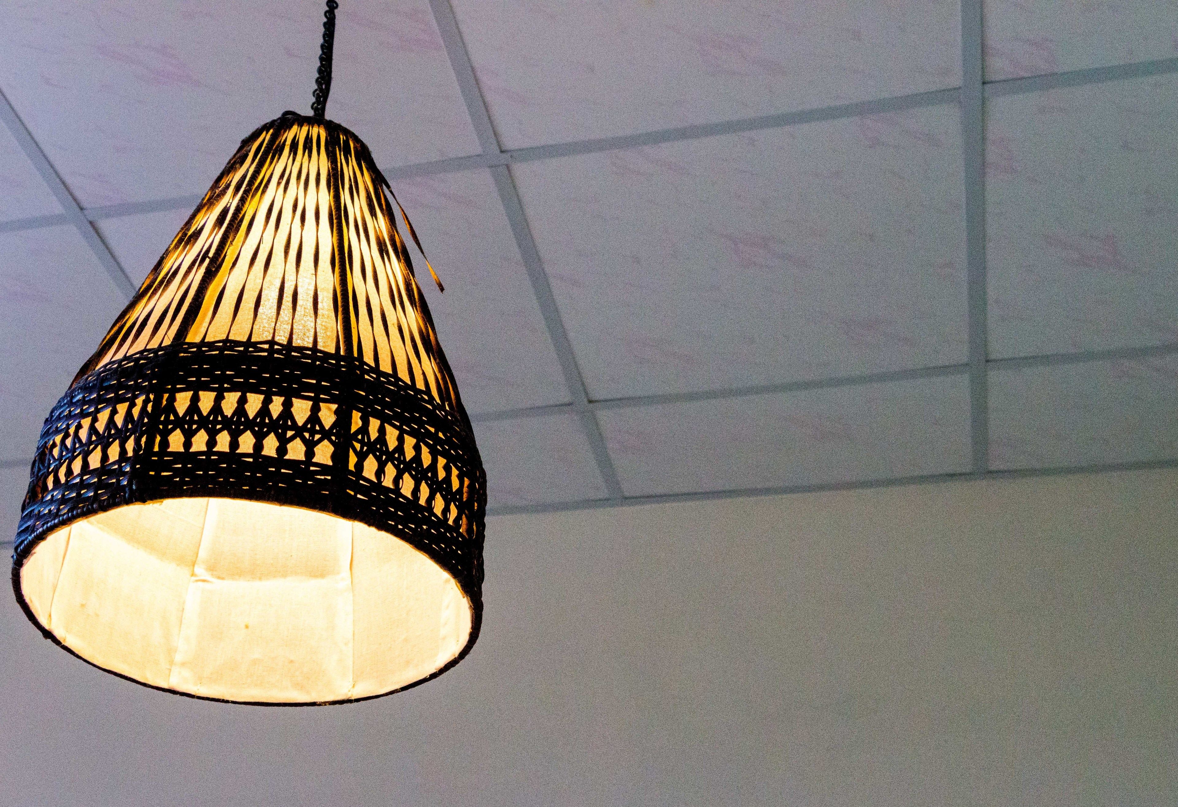 A hanging light fixture with a woven design.