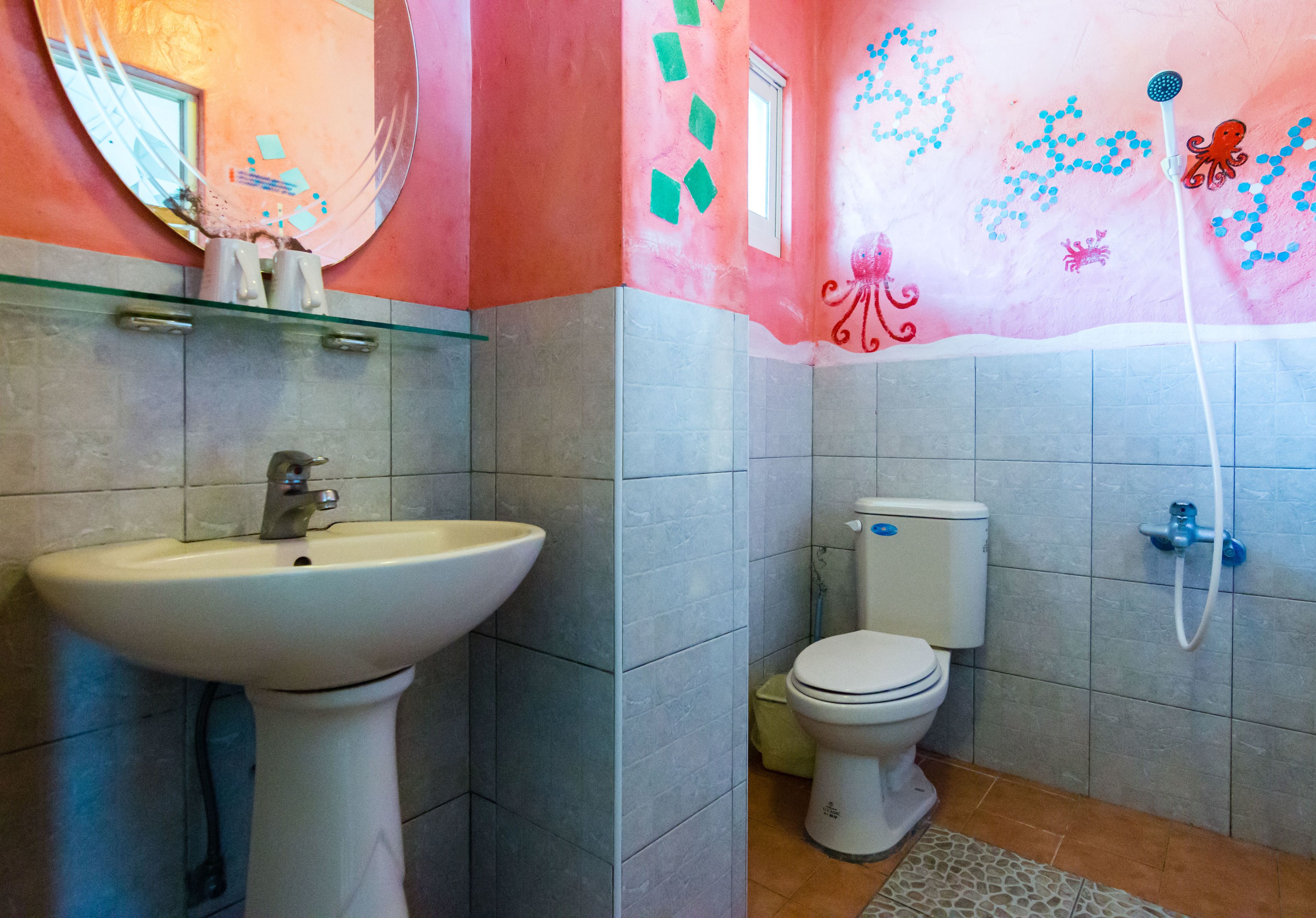 Un baño con lavamanos, inodoro y ducha.