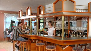 A bar area with stools, a counter, and shelves of glassware and bottles. - Hotel Schwartze (Weimar)