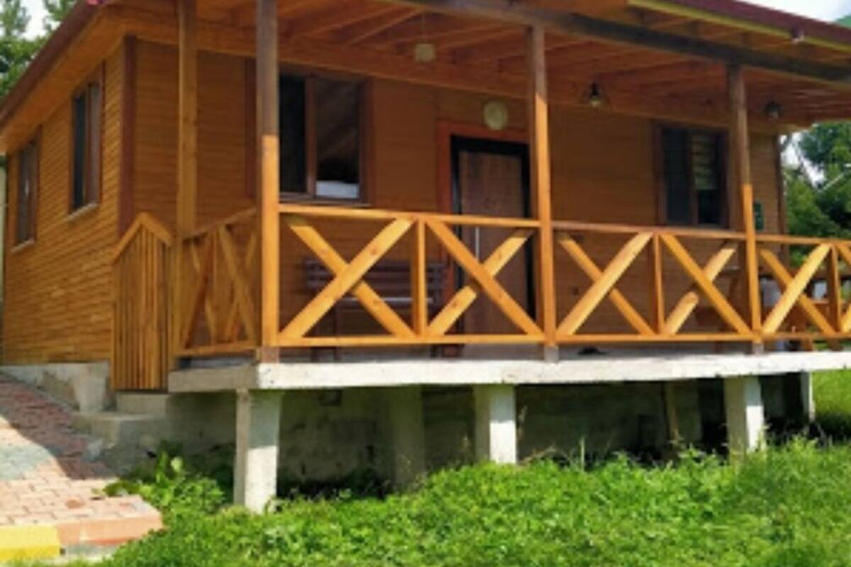 Eine Holzhütte mit Veranda, Tür und Fenstern.