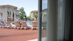 A poolside area with lounge chairs and a swimming pool. - The Blue Lagoon Deluxe Hotel (Fethiye)