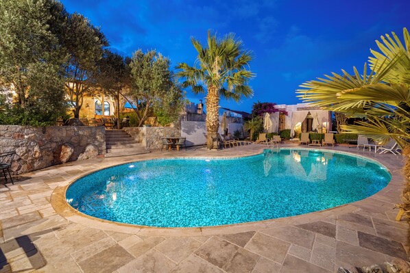 Alberca al aire libre, sombrillas en la alberca y camastros