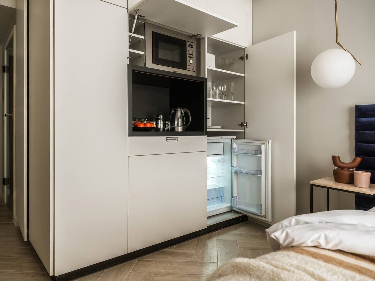A compact kitchenette with a microwave, refrigerator, and coffee maker.