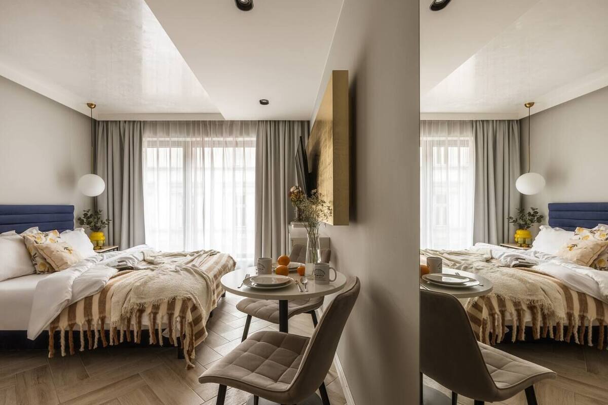 Ein Hotelzimmer mit zwei Betten, einem Esstisch und einem Stuhl.
