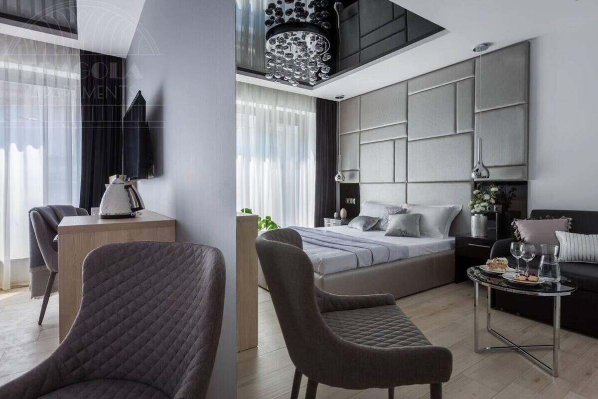 Ein modernes Schlafzimmer mit Bett, Nachttischen, Schreibtisch und Sitzgelegenheit.