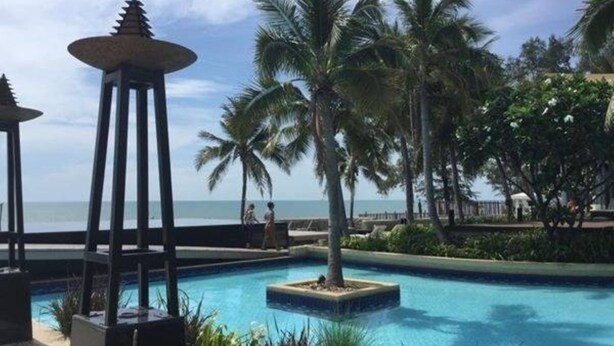 A pool area with palm trees and a view of the ocean. - Teddy Bear Villa Hua Hin 2 (Cha-am)