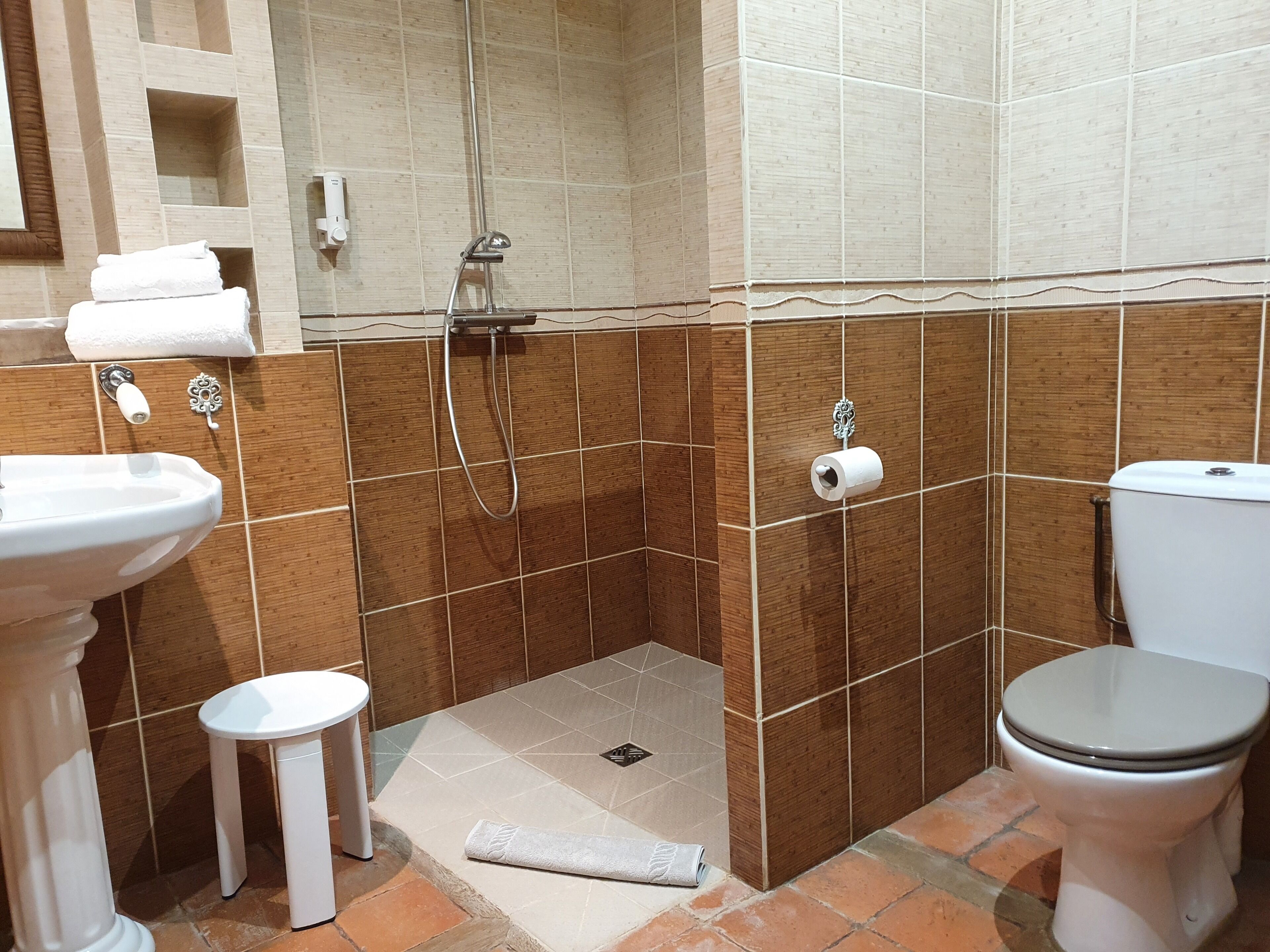 Une salle de bain comprenant un lavabo, des toilettes et un espace douche.