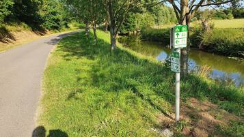 A pathway beside a river with directional signs.