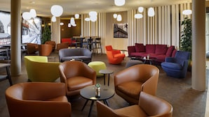 Un espace de détente moderne avec des canapés en cuir, un coin repas et une fresque murale.
