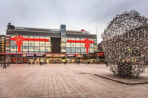 A modern shopping center with large glass windows and red gift bows.