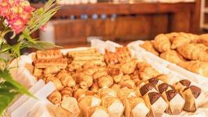 Una mesa de buffet con diversos pasteles y productos de panadería, incluyendo croissants y hojaldras, en un ambiente de restaurante.
