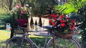 A bicycle with a basket containing flowers and a wicker basket attached to the back.