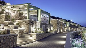 A modern building with stone steps and a glass railing, illuminated by lights. - EmGard Suites Kythnos (Kithnos)