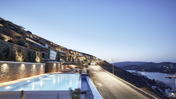 A hillside hotel with a swimming pool, outdoor seating, and a view of the sea. - EmGard Suites Kythnos (Kithnos)