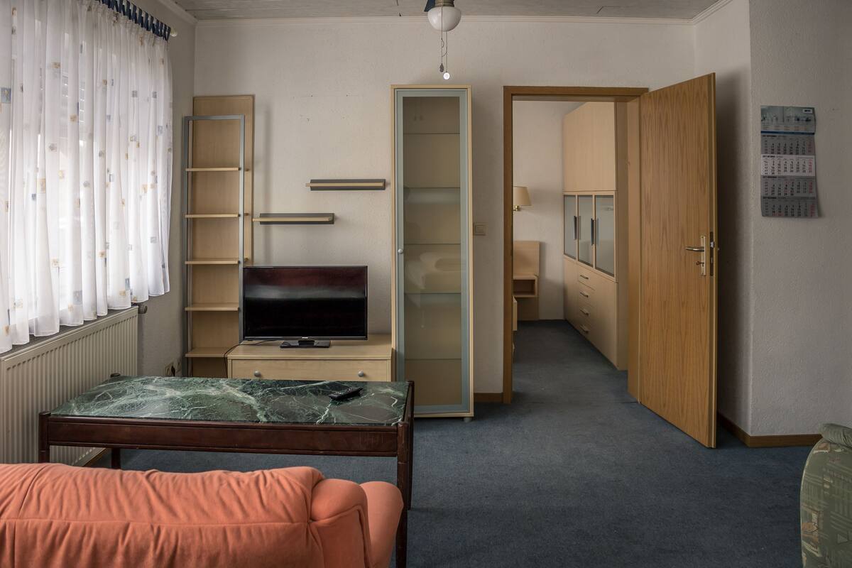 A hotel room with a bed, a TV, a desk, and a wardrobe.