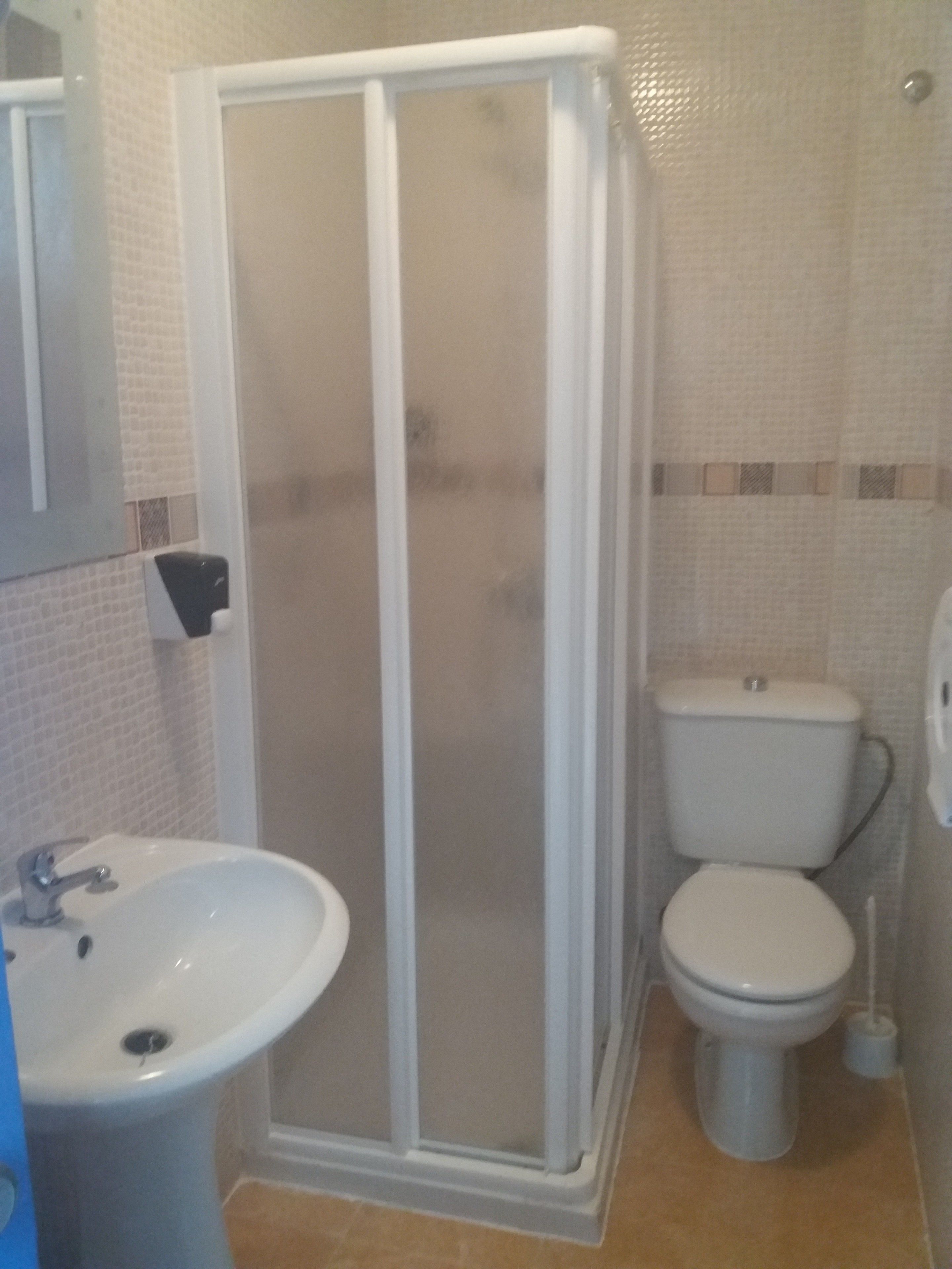 Un bany amb plat de dutxa, un lavabo i un vàter.