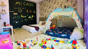 A child's bedroom with a bed, play area, and a wall with educational decorations. - Mi Casa Bed and Breakfast (Taitung)