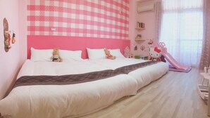 A large bed with two pillows, a teddy bear, and a Hello Kitty chair. - Mi Casa Bed and Breakfast (Taitung)