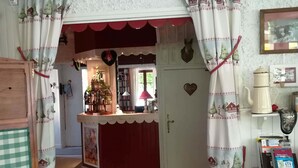 Ett mysigt köksområde med en central köksö, en hängande lampa och en dörr som leder till ett annat rum.