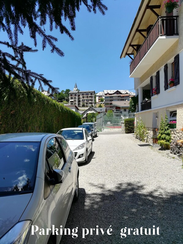 Una calle residencial con coches aparcados, una iglesia y casas con balcones.
